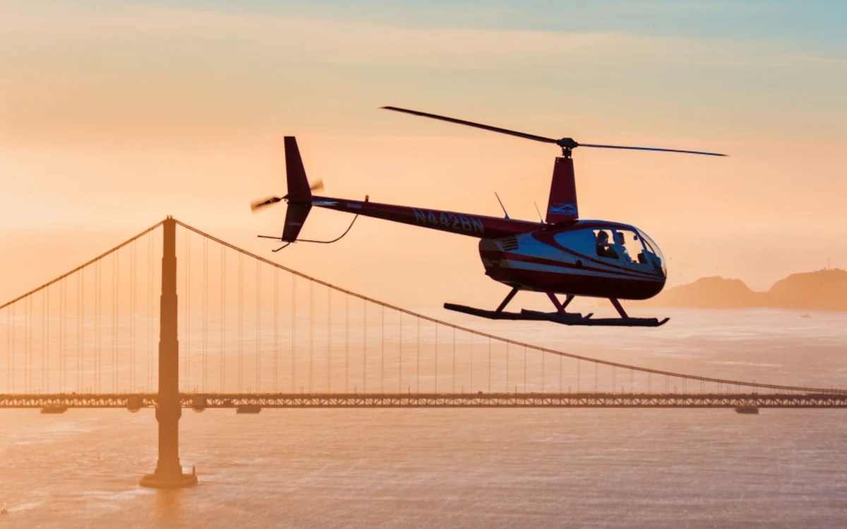 Um helicóptero acima da Golden Gate Bridge com a Baía de San Francisco ao fundo